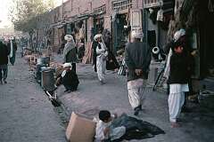 Open front shops along a sidewalk in Herat.