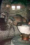 A blindfolded camel, going around endlessly inside, drives a mill grinding grain for the traditional Afghan bread, “nan” in Herat.