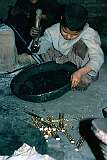 Some children must work from an early age, like this little boy from Herat who is pounding the clay moulds in which brass ornaments were made.
