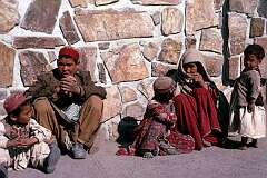 A family of one of Afghanistan's nomadic peoples waiting on the street for their husband and father to return from business.