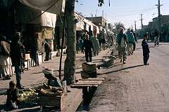 The main street of Kandahar, near Maiwand Square, is a bustling place with open-fronted shops and street vendors.