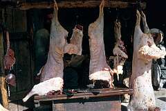 A butcher's shop on the main street in Kandahar. Carcasses are hanging outside, covered in flies, but as the meat is used in stews, cooked for hours, it is quite  safe.