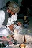 Making stone beads painstakingly by hand in a small workshop. Small boys will later drill tiny holes in them with a hand drill.
