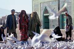 Thousands of white pigeons make their home near the shrine of Ali, the Fourth Caliph. The women's dress identifies them as Turkmen, like in neighbouring Turkmenistan.