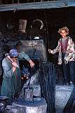 A smith's workshop in a back street of Mazar. The boy helps by operating a large bellows. Children often have to work at an early age.