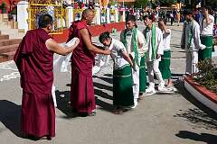 The student dancers receive a “khata” ceremonial shawls around their neck by a monk, as appreciation, after their performance.