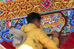Touching up a painting in the portal of the main assembly hall.