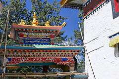 Painters on scaffolding working on the paintings on an ornamental gate.