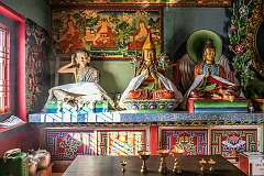 A statue of Jetsun Milarepa and other Buddhist statues, in the temple under the giant Buddha statue.