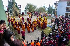 View of monks with ceremonial headdresses at the place where the “Torma”, spiritual cake, will be burnt. They carry pairs of Cymbals (“Bub”) and Ritual Drum (“Choe-Nga”).