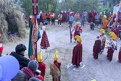 View of monks with ceremonial headdresses at the place where the “Torma”, spiritual cake, will be burnt. They carry pairs of Cymbals (“Bub”) and Ritual Drum (“Choe-Nga”).