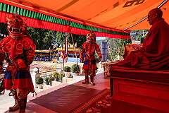 Masked dancers in front of Geshe Dondup Tsering, the abbot of the monastery, before descending to the dancing ground.