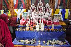 Sacred objects made from butter in the room with the images of the three protecting gods.