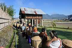 Women bringing baskets of rice to the rice barn of the bride's in-laws, in the Eli ceremony.