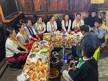 Wedding guests in the house of the Radhe clan, during the Eli ceremony, Tajang Village. A man counts out money, to give to each woman; in the past they gave were expensive presents.