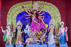 Durga, the multi-armed goddess and other Hindu deities, on the stage in a temporary temple in a street, for the Navaratri Festival.