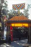 A decorated gate with the Deer and Dharma Wheel, important Buddhist symbols, and the flag of Tibet; in “Little Lhasa”, the centre of Tibetans in exile.
