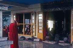 A Buddhist nun praying at an entrance portal of the Tsuglagkhang.