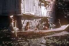 Paddling a canoe on a canal in Srinagar.