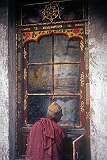A Buddhist nun turning a large prayer wheel at the monastery of Alchi.