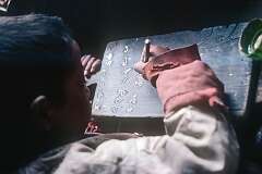 Puntsog Dorji, doing homework from school, writing in Tibetan characters.