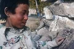 A boy reading "Om mani padme hum" in Tibetan script on “mani” stones in Shey; it is a sacred Sanskrit mantra in Tibetan Buddhism, most associated with Avalokiteshvara, the Bodhisattva of Compassion.