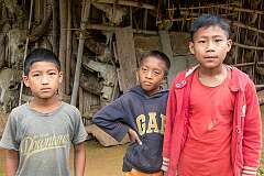 Three Konyak Naga boys in front of the Angh's house.