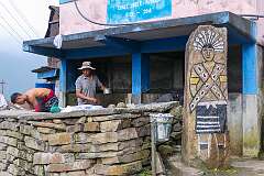 Men working and a painting of a Naga warrior, in the upper Angami Naga village of Khonoma.