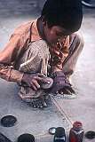 A young boy earning a few rupees by polishing shoes.