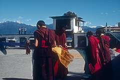 Monks fastening Buddhist prayer flags in the plaza of Rumtek Monastery.