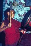 A young Buddhist novice monk beating a drum in Rumtek Monastery.