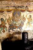 A lingam, the phallic symbol associated with the god Shiva, against a backdrop of a painting of the elephant headed god Ganesha, enshrined around the outer walls of the Brihadisvara Temple.