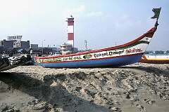 Fishing boats with the lighthouse on Gandhi Beach, south of Marina Beach.