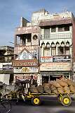 A heavily laden buffalo cart in front of shops in Kanchipuram.