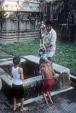 A young boy is doused with water at a Tīrtha or theertham (sacred well), in the Ramanathaswamy Temple of Rameswaram; the water is believed to have purifying powers.