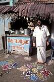 A “Kolam” traditional rice-paste design in front of a tea shop with its owner, Rameswaram.