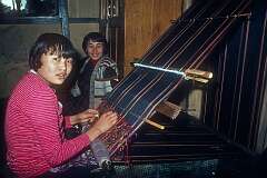 Yangdzon, weaving a caerpet, with Yishey Wangmo watching.