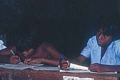 Two boys writing lessons.