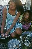 Marlyna, Snappy Arawatau's wife and their daughter Rita, preparing food at home in Tuarabu village.