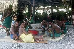 Young men having their meal outside the maneaba of Roreti village.