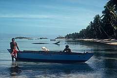 Men with their canoe in the lagoon in Kuma.