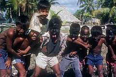 Boys with their faces painted for fun, posing in Makin village.