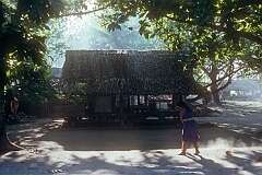 Sweeping the ground in front of her “buia”, traditional open-sided house in Makin village.