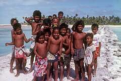 Children of Buariki, with the coral causeway.