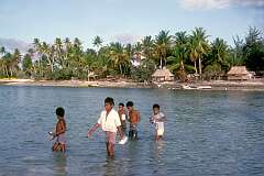 Children crossing at low tide between the islets of Buota and Tanaea.