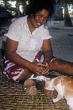 Titau, the wife of Taubuki, the local policeman, shaving coconut, in the village of Abaokoro.